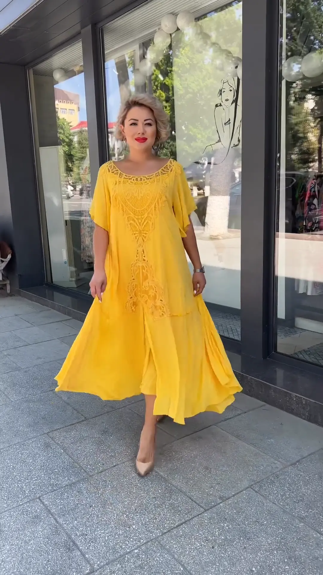 Blonde Frau im fließenden gelben Kleid