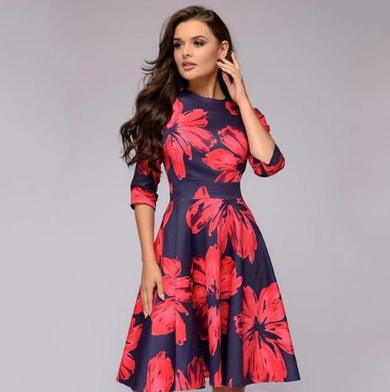 Frau, die ein rotes, florales retrozo edles mittellanges Kleid trägt